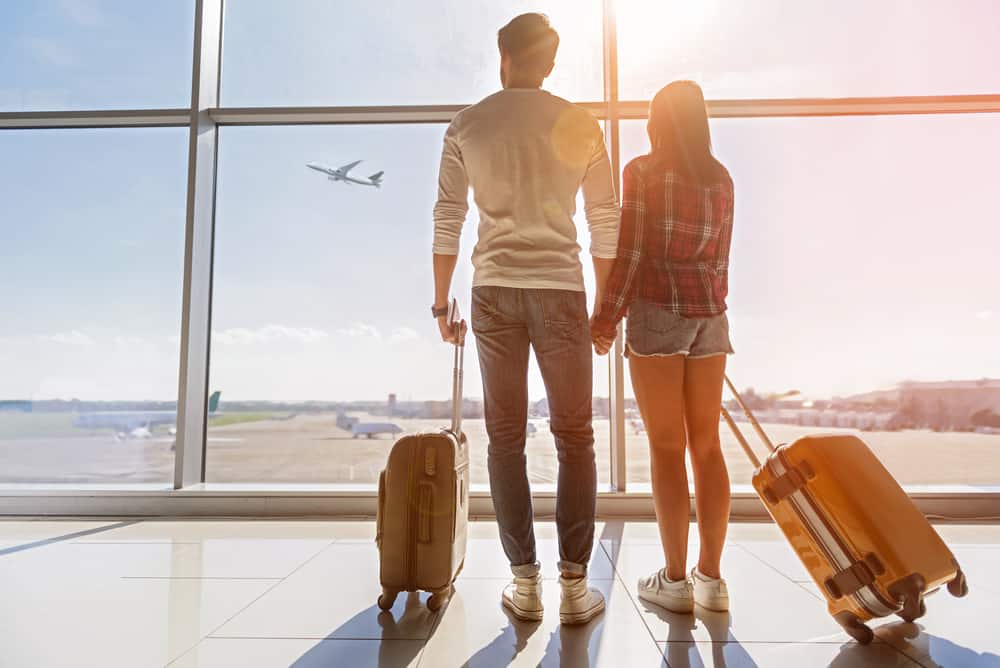 mladý pár se zavazadly cestuje na dovolenou